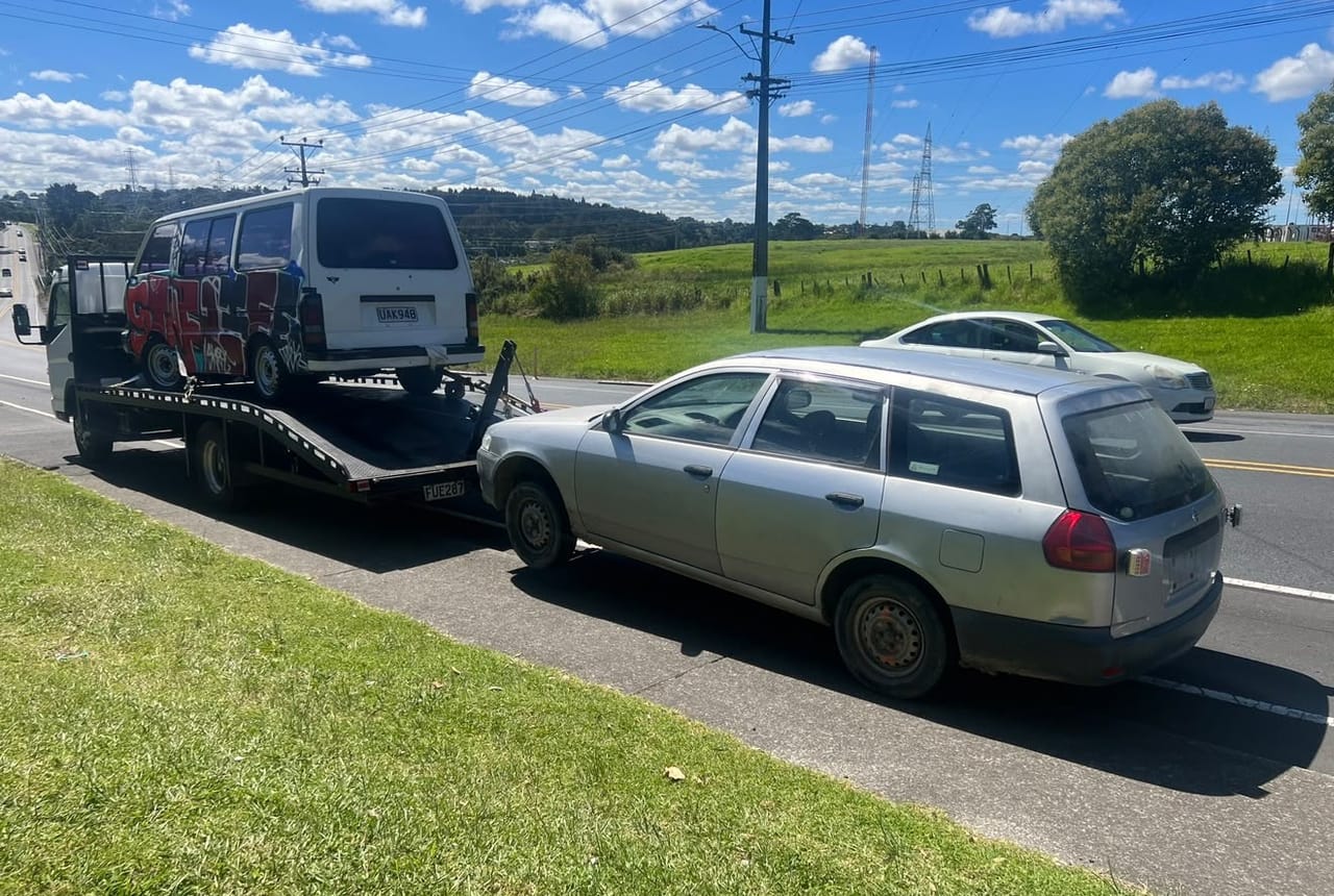 Car Wreckers Palmerston North tow truck removing an unwanted van and car on a Manawatū road